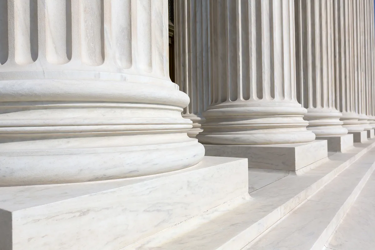Close-up of several classical white marble columns with fluted designs.