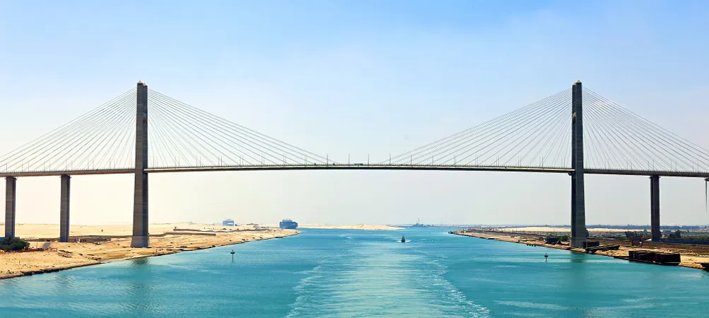 Suspension bridge over a turquoise waterway.