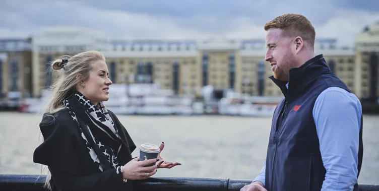 woman and man talking next to a river