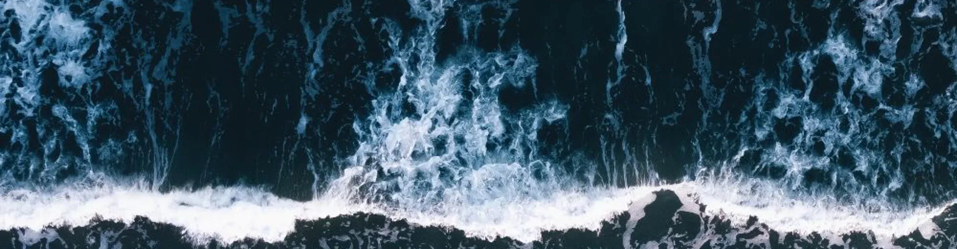Aerial view of ocean waves and foam.