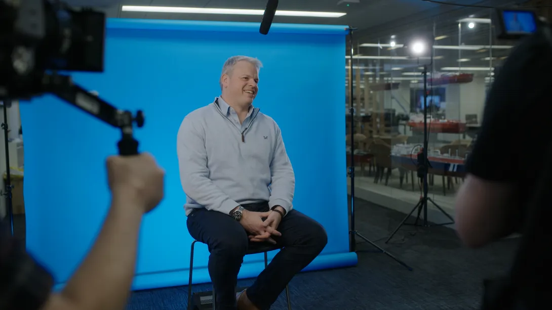 Man sitting in front of film set with blue background