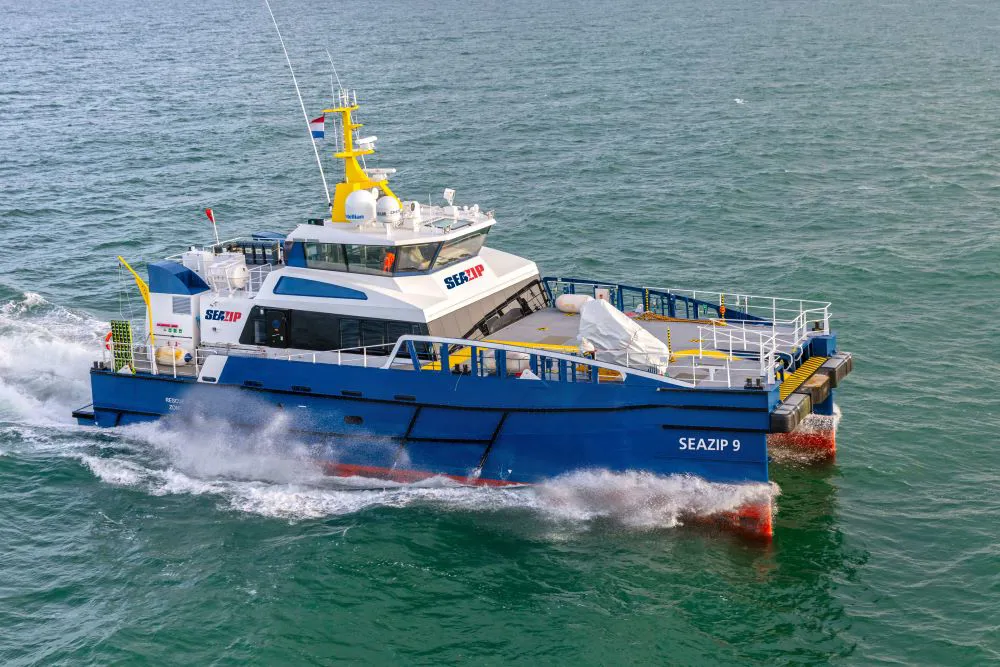 A blue and white vessel named "SEAZIP 9" at sea.