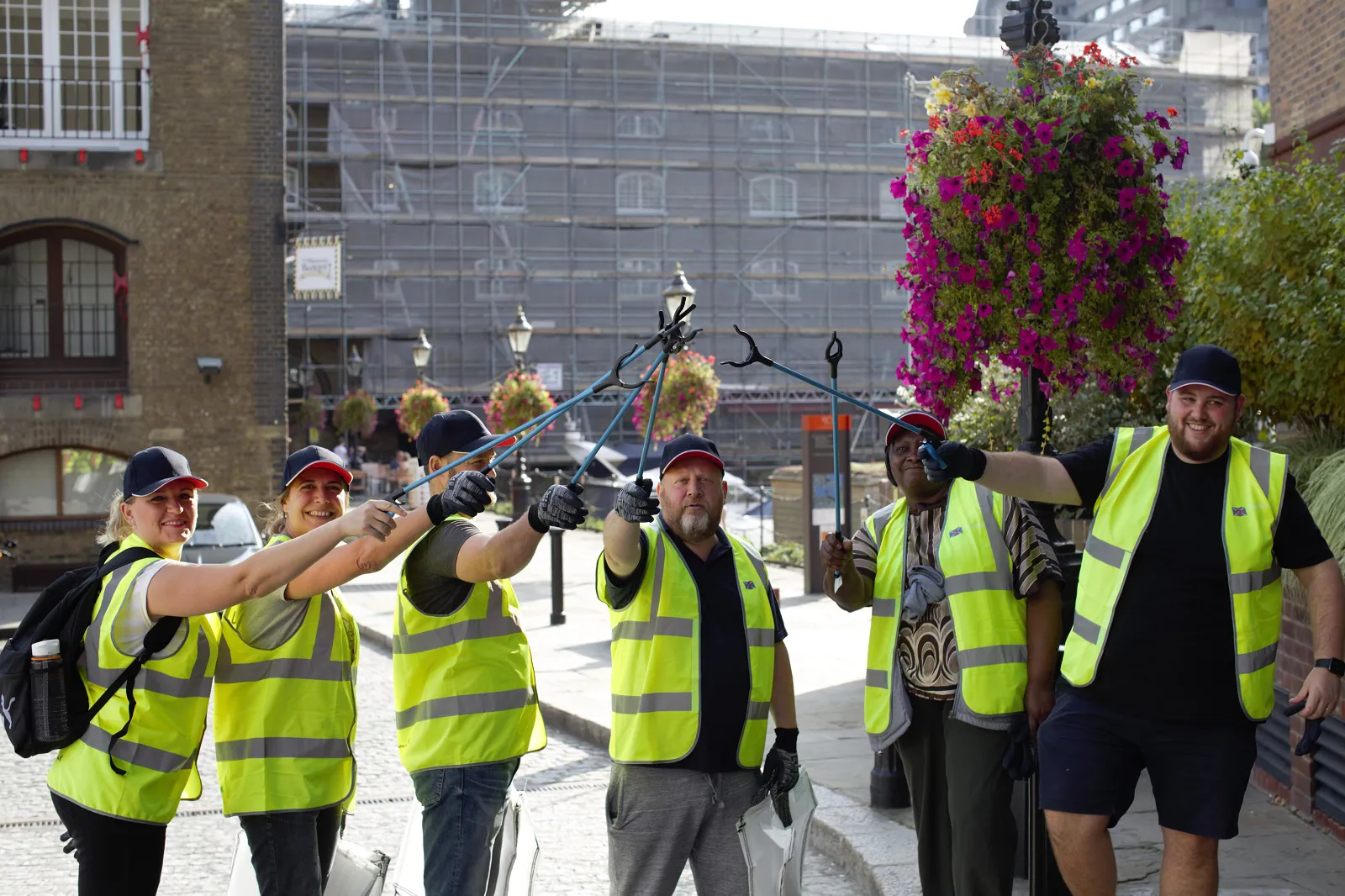 group of DOEL employees in hi vis jackets with litter pickers