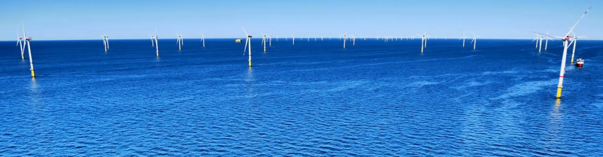 Offshore wind turbines in deep blue water.