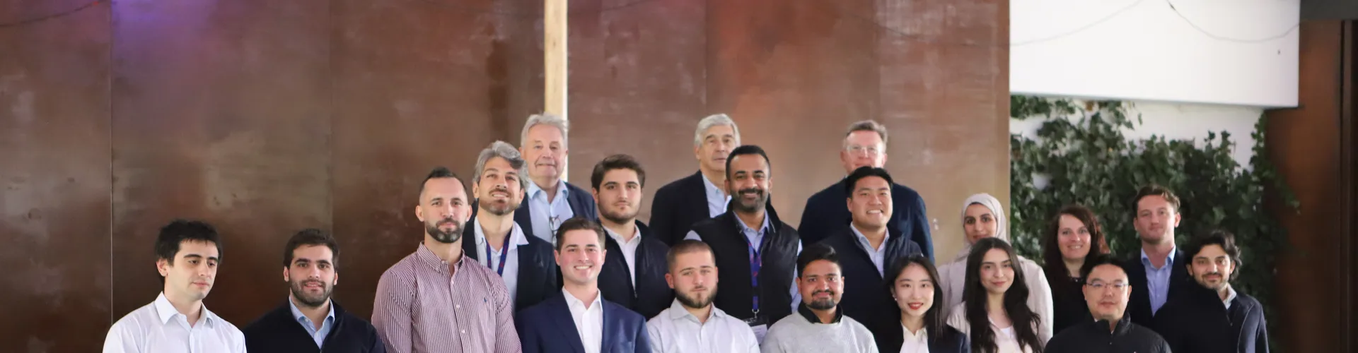Diverse group in business attire standing outdoors in two rows.