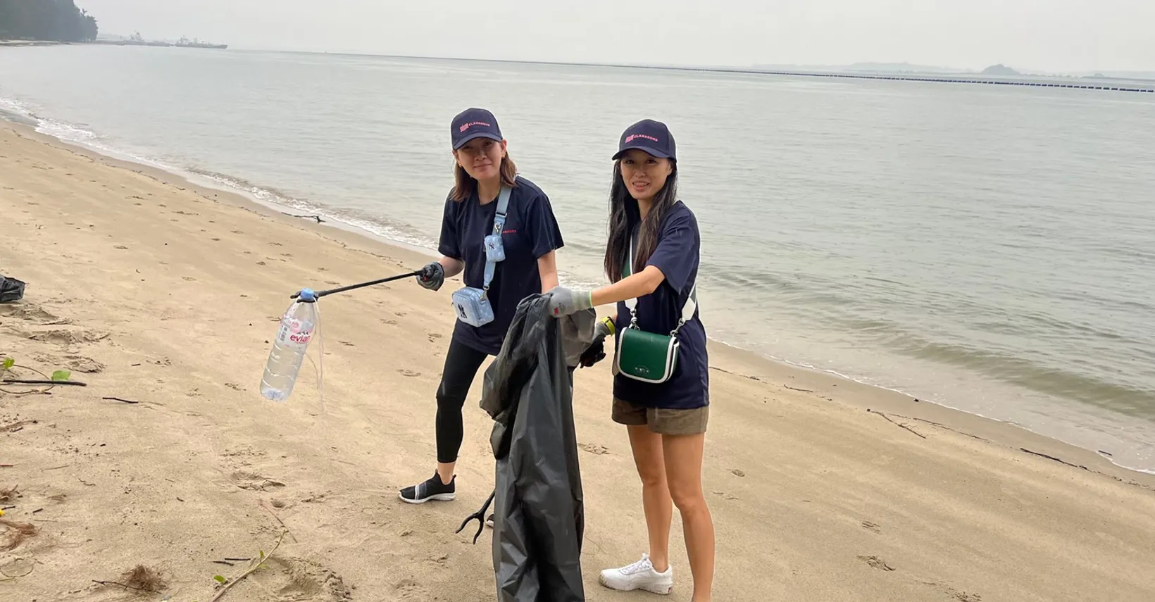 Two women cleaning a beach.