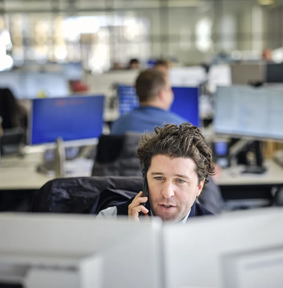 Man talking on the phone in an office environment.
