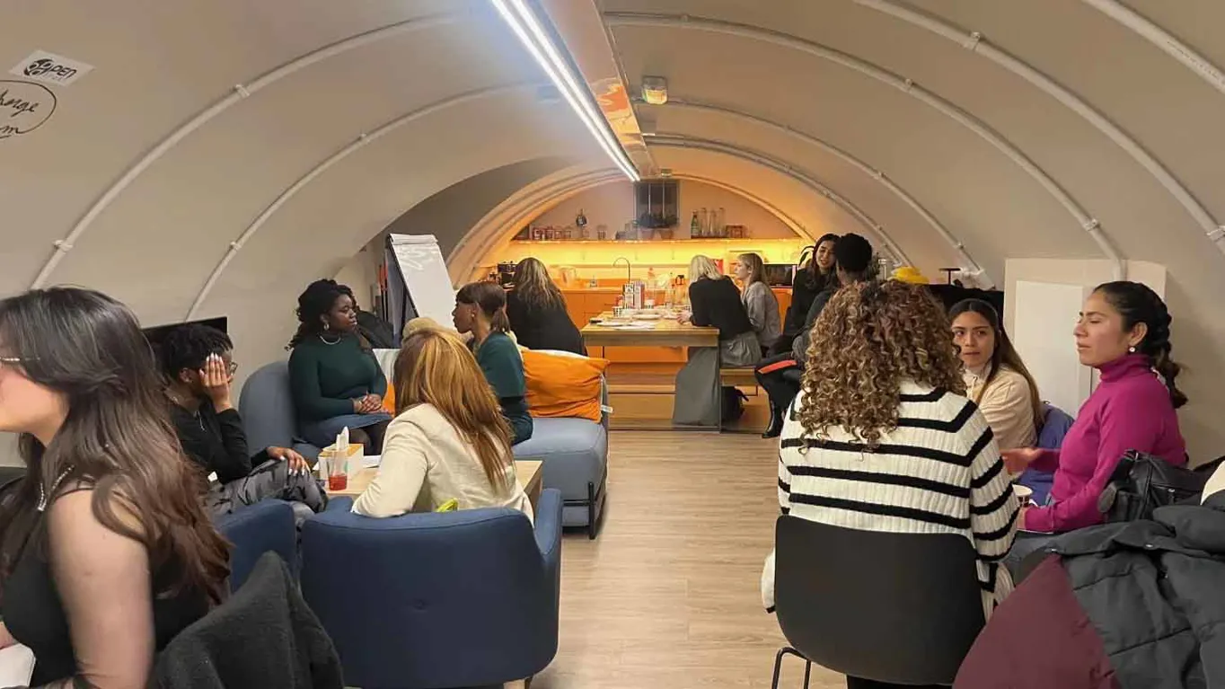 People chatting in a cozy, modern cafe setting.