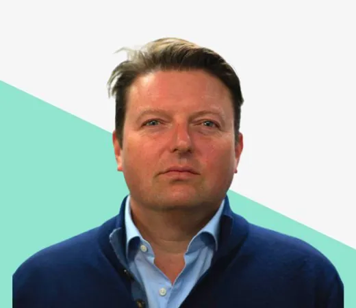 Person in a navy sweater against a light background with a geometric design.