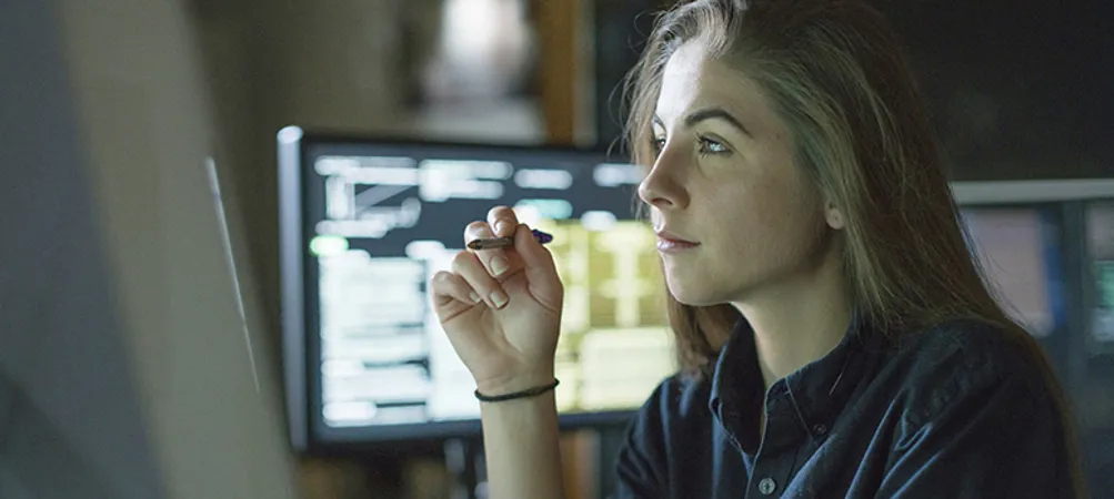 Woman monitors dark office
