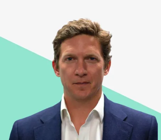 Man in a suit against a geometric background.