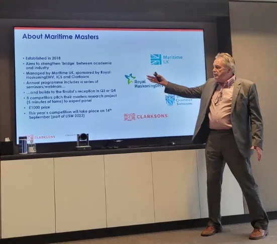 Man presenting information about Maritime Masters program.