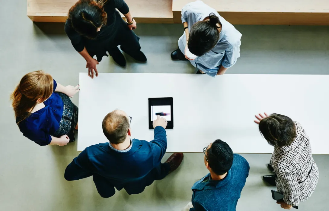 group of people gathered around a table discussing work