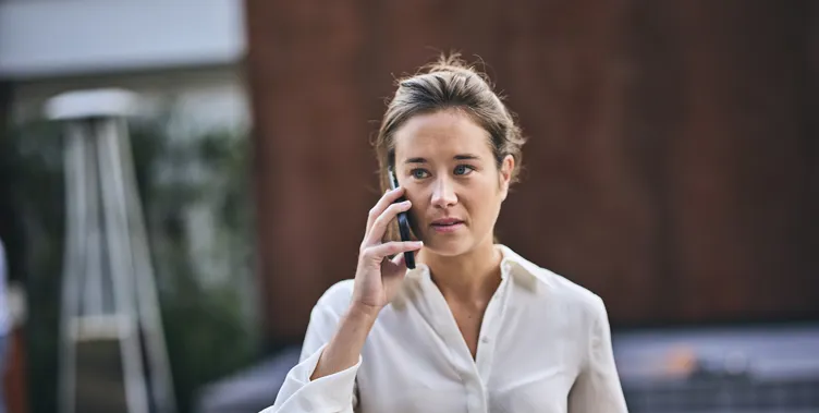 woman in white shirt on phone, outside, walking