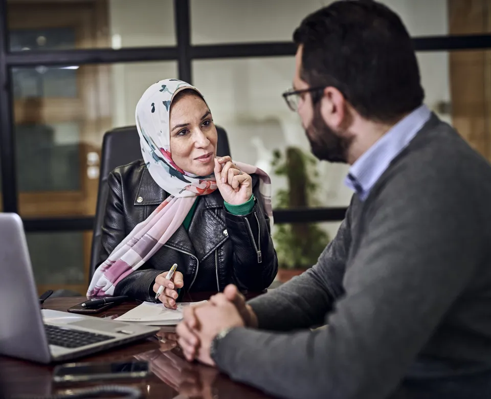 woman talking to a colleague and gesturing with her hands