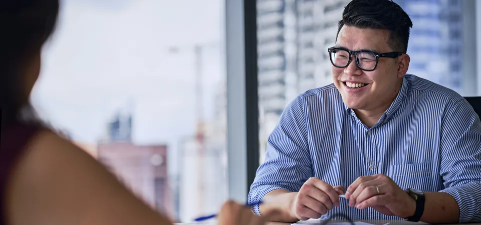 Person smiling during a conversation in an office.