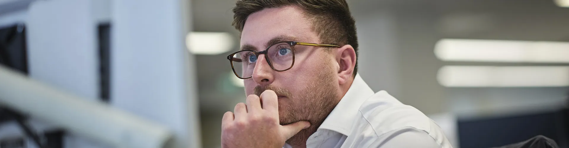 Man looking thoughtfully at a computer screen.