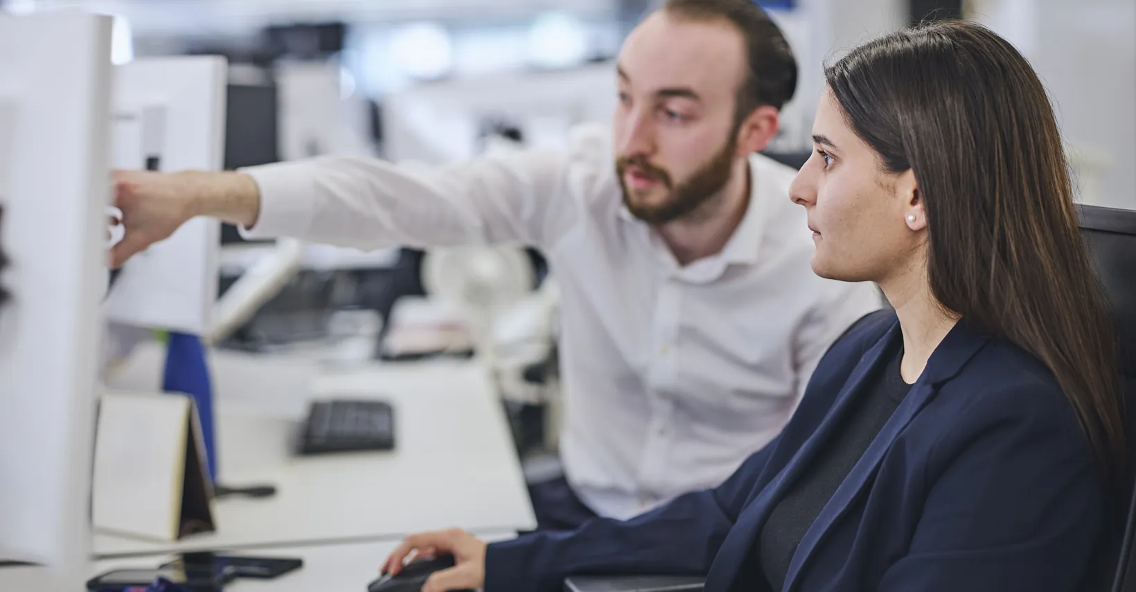 Two colleagues working together at a computer.