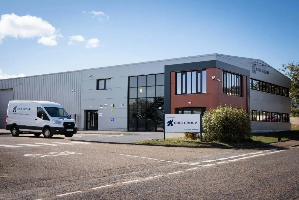 Modern building with a delivery van parked outside.