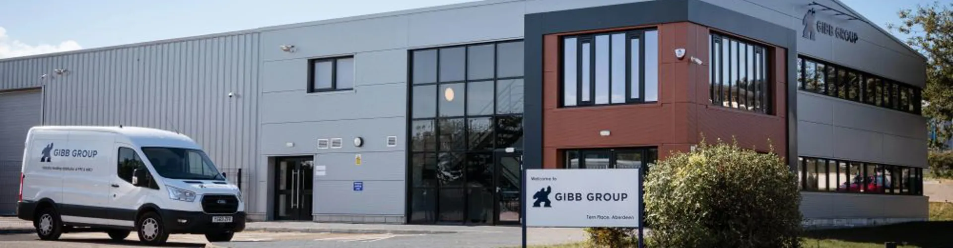 Modern building with a delivery van parked outside.