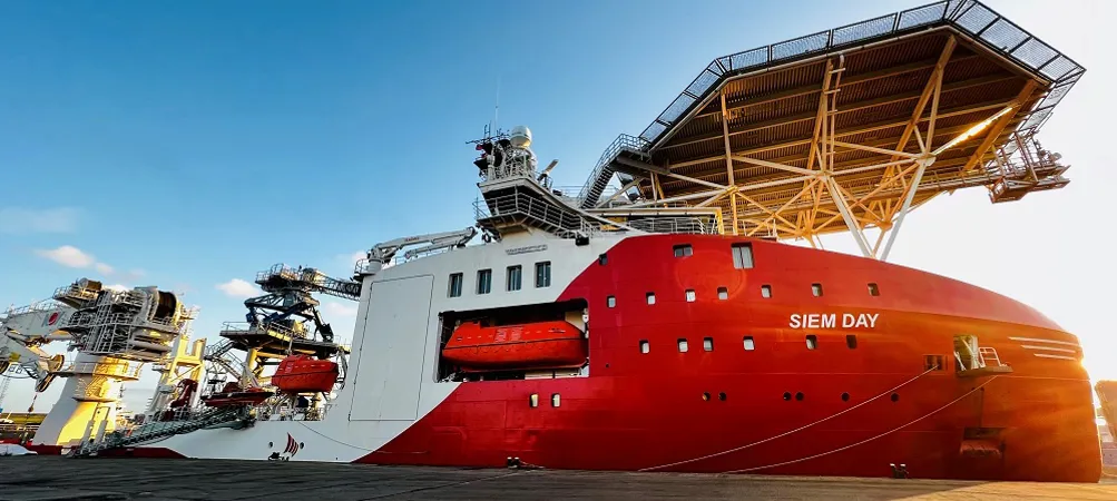 Red ship named "SIEM DAY" docked at port.